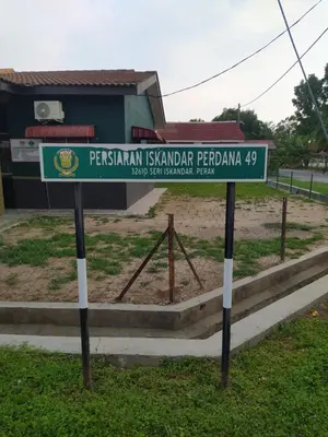 a street sign in front of a building at Atbas Homestay No 1 in Seri Iskandar