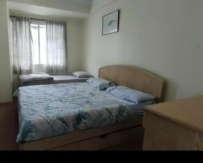 a bedroom with two beds in a room with a window at Desa Anthurium Apartment in Tanah Rata