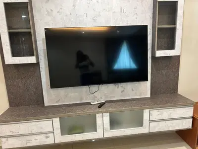a flat screen tv sitting on top of a entertainment center at Orkid Apartment 2 in Cameron Highlands