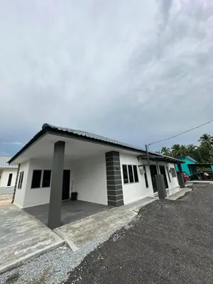 a white building with two pillars in front of it at Homestay Bajet Cikgu Amin in Bagan Serai