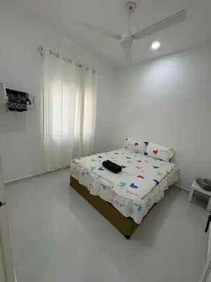 a bedroom with a bed in a white room at Homestay Bajet Cikgu Amin in Bagan Serai
