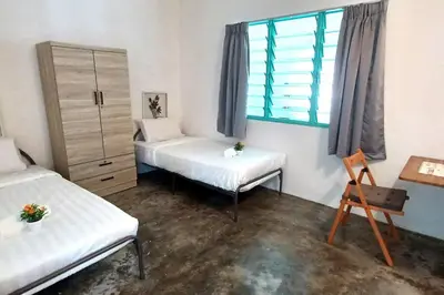 a room with two beds and a window at Pepper Hillside Village Home in Tanjung Bungah