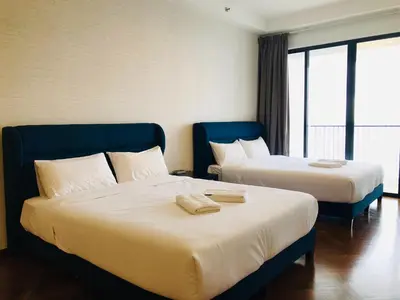 a hotel room with two beds with towels on them at The Landmark Seaview Suite in Tanjong Tokong