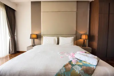a bedroom with a large white bed with two lamps at The Landmark Seaview Suite in Tanjong Tokong
