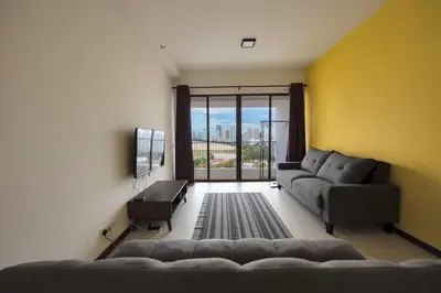 a living room with a couch and a large window at The Landmark Seaview Suite in Tanjong Tokong