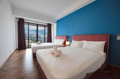 a bedroom with two beds with a stuffed animal on it at The Landmark Seaview Suite in Tanjong Tokong