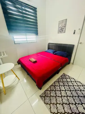 a large red bed in a room with a table at D Alamanda Islam Homestay in Kuala Kangsar