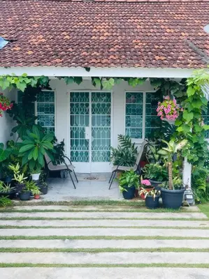 a porch of a house with pots of plants at Heritage Cottage in Georgetown in Jelutong