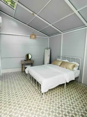 a bedroom with a bed and a table at Heritage Cottage in Georgetown in Jelutong