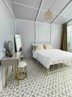 a bedroom with a bed and a table and a mirror at Heritage Cottage in Georgetown in Jelutong