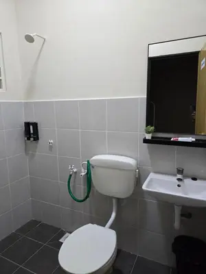 a bathroom with a toilet and a sink at Humaira Homestay Teluk Intan in Teluk Intan