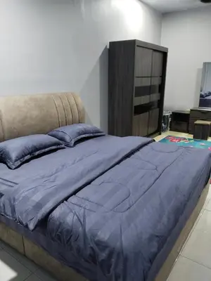 a bedroom with a large bed with blue pillows at Homestay Lyn Impian in Tanjung Rambutan