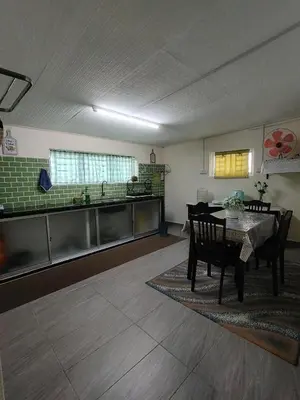 a kitchen and dining room with a table and chairs at Sri MaLati Homestay and Event Space in Balik Pulau