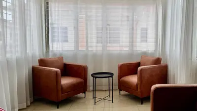two chairs and a stool in front of a window at no7 HOMESTAY in Tanjung Karang