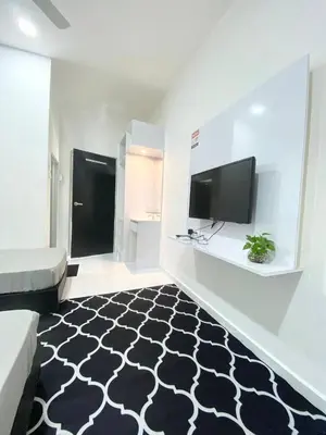 a living room with a black and white patterned carpet at ROOMSTAY KOME Merapoh in Perhentian Merapuh Baharu