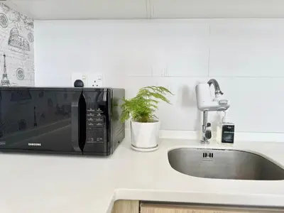 a kitchen counter with a microwave and a sink at Tropicana 218 Macalister #Georgetown #Infinity Pool #2pax studio suite #1 Queen #Quality well maintained #Private host in George Town
