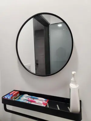 a mirror on a wall next to a shelf with magazines at CATAILIS Metropol Serviced Apartment Bandar Perda Bukit Mertajam near Penang Bridge in Bukit Mertajam