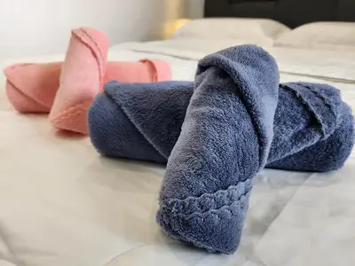 a pile of towels sitting on a bed at CATAILIS Metropol Serviced Apartment Bandar Perda Bukit Mertajam near Penang Bridge in Bukit Mertajam