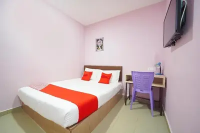 a bedroom with a bed and a desk and a chair at CMN Hotel & Homestay in Sungai Petani