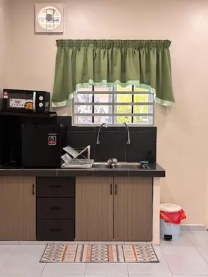 a kitchen with a sink and a window at Lodging Mak Endon in Seri Manjung