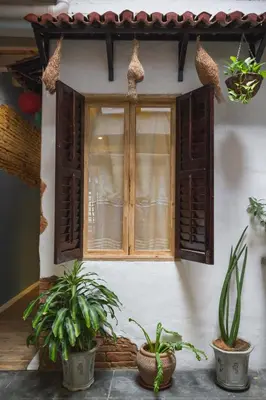 a window of a house with two potted plants at My Guesthouse 109 - SELF CHECK IN in George Town