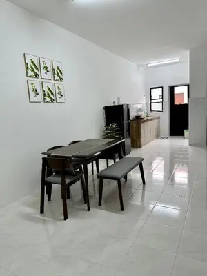 a dining room with a table and chairs and a kitchen at Pitaloka The Lakes Homestay in Batu Gajah