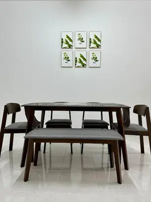 a dining room table and chairs in front of a white wall at Pitaloka The Lakes Homestay in Batu Gajah
