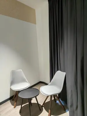two white chairs and a table in a room at Galaxy Hotel Bandar Perda in Bukit Mertajam