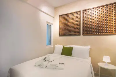 a bedroom with a white bed and a window at Maritime Suites by Stellar ALV in Jelutong