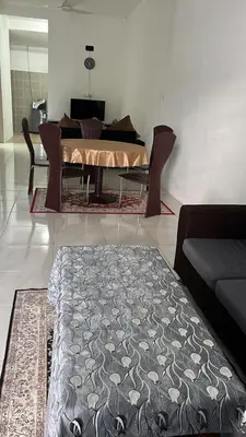 a dining room with a table and a couch at Double H Homestay in Tanjung Rambutan