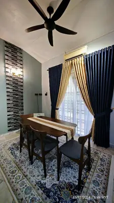 a living room with a table and a ceiling fan at Homestay Santai Bertam in Kepala Batas