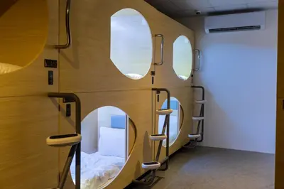 a room with three circular windows and a bed at Resthub in George Town