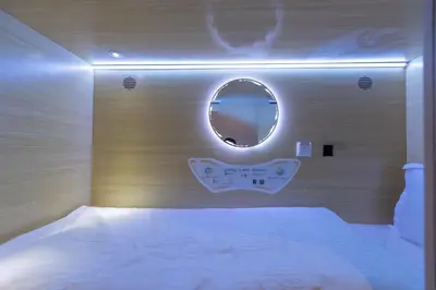 a bedroom with a white bed and a mirror at Resthub in George Town
