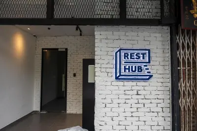 a reset hub sign on a white brick wall at Resthub in George Town