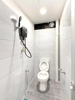 a bathroom with a toilet and a shower stall at Sofu Inn in Jelutong