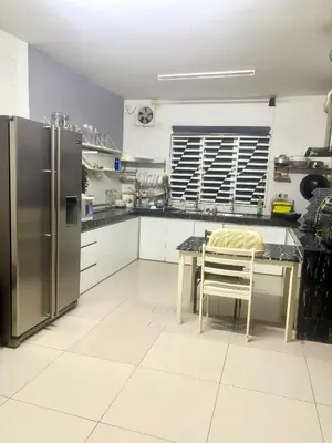 a kitchen with a table and a stainless steel refrigerator at Hannah Homestay Ipoh in Ipoh