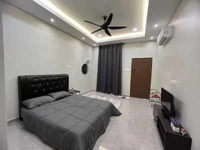 a bedroom with a bed and a ceiling fan at Rimbunan Padi Roomstay in Bagan Serai
