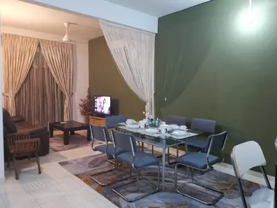 a dining room with a table and chairs at Alle Vacation Homes Tambun Ipoh in Ipoh
