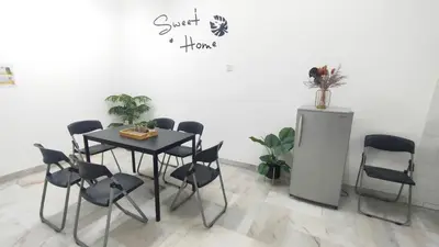 a table and chairs in a room with a white wall at 33 HOMESTAY 4 Room 5 MINUTE TO LEANING TOWER in Teluk Intan