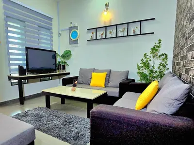 a living room with a couch and a tv at 1813 HOME STAY 8 Roon 6 Bath 5MINUTE TO LEANING TOWER in Teluk Intan