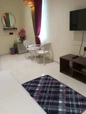 a living room with a tv and a table and chairs at D'Permata Roomstay Kampung Pelet in Kubang Semang