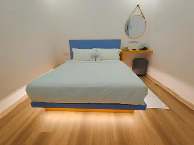 a bedroom with a bed with a blue headboard and a mirror at TREASURE BOX At Heritage Georgetown in George Town