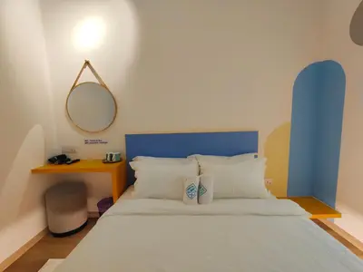 a bedroom with a bed with a blue headboard and a mirror at TREASURE BOX At Heritage Georgetown in George Town