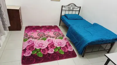 a bedroom with two beds with flowers on the floor at Homestay Kak Rose 2 Kuala Lipis in Kampong Temperah