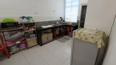 a room with a kitchen with a counter and a refrigerator at Homestay Kak Rose 2 Kuala Lipis in Kampong Temperah
