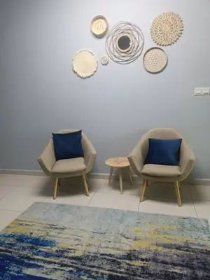 a room with two chairs and a table and mirrors at Homestay D'sasz Meru Ipoh in Ipoh