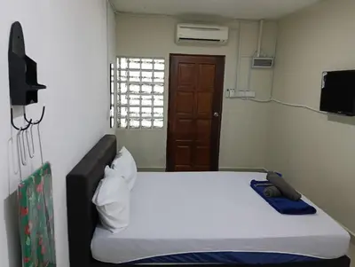 a bedroom with a bed and a brown door at JSW PRAMLee Georgetown Penang in George Town