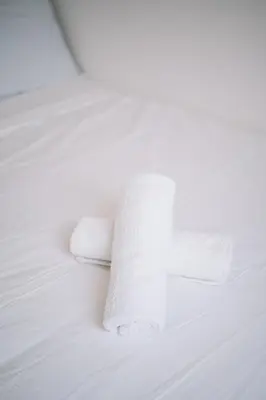 a roll of toilet paper on a white bed at NEW The Sun 3Bedrooms 10pax 2CP in Bayan Lepas
