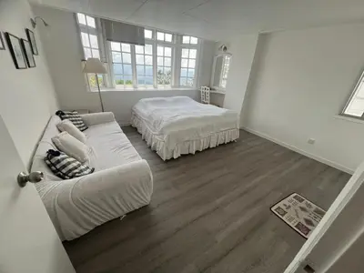 a white bedroom with a bed and a couch at Misty at Fraser's Hill in Bukit Fraser