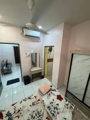 a bedroom with a bed and a bathroom with a mirror at Wika Homestay in Kulim